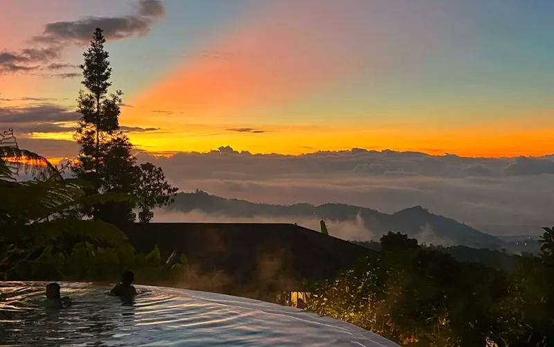 Sunset over the infinity pool and mountains at Alta Vista Bali